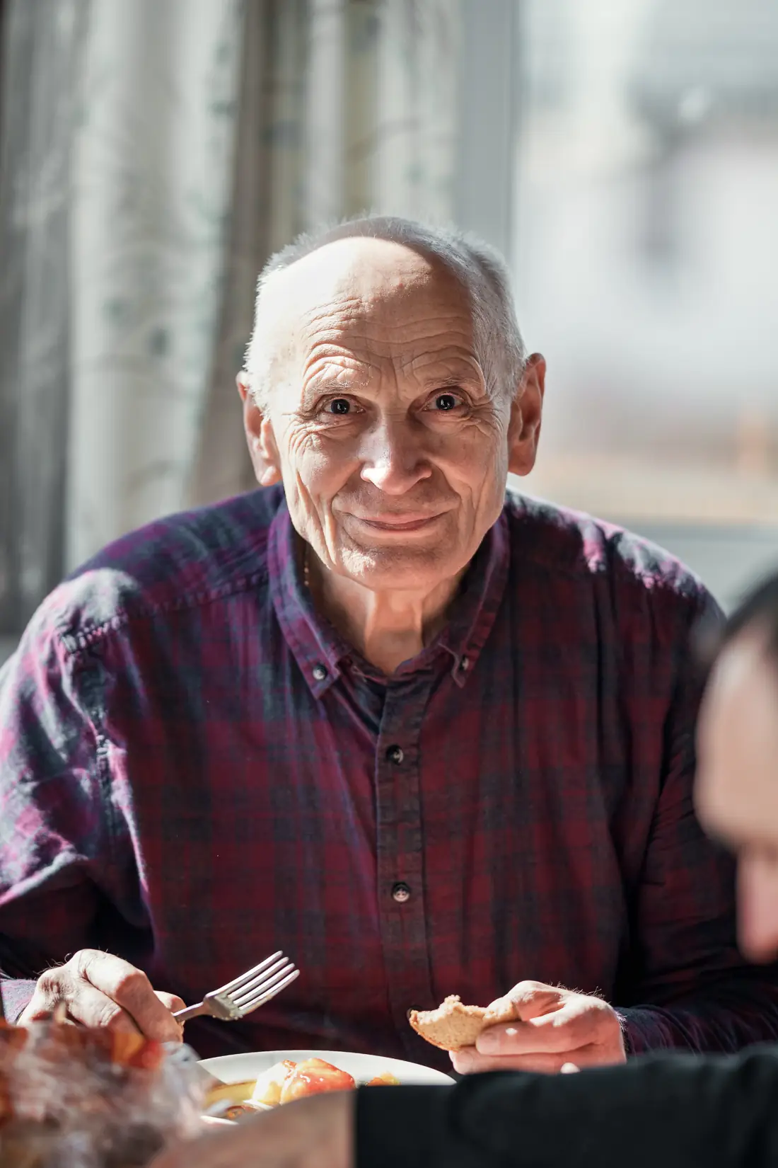 Un résident partage son repas, souriant