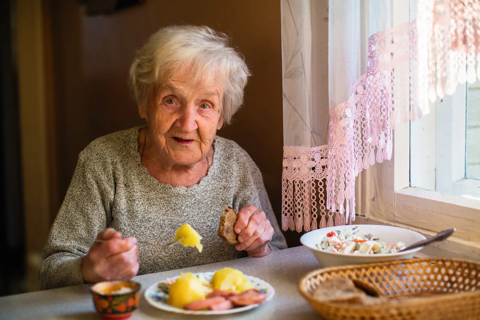 Une résidente savoure son repas à table